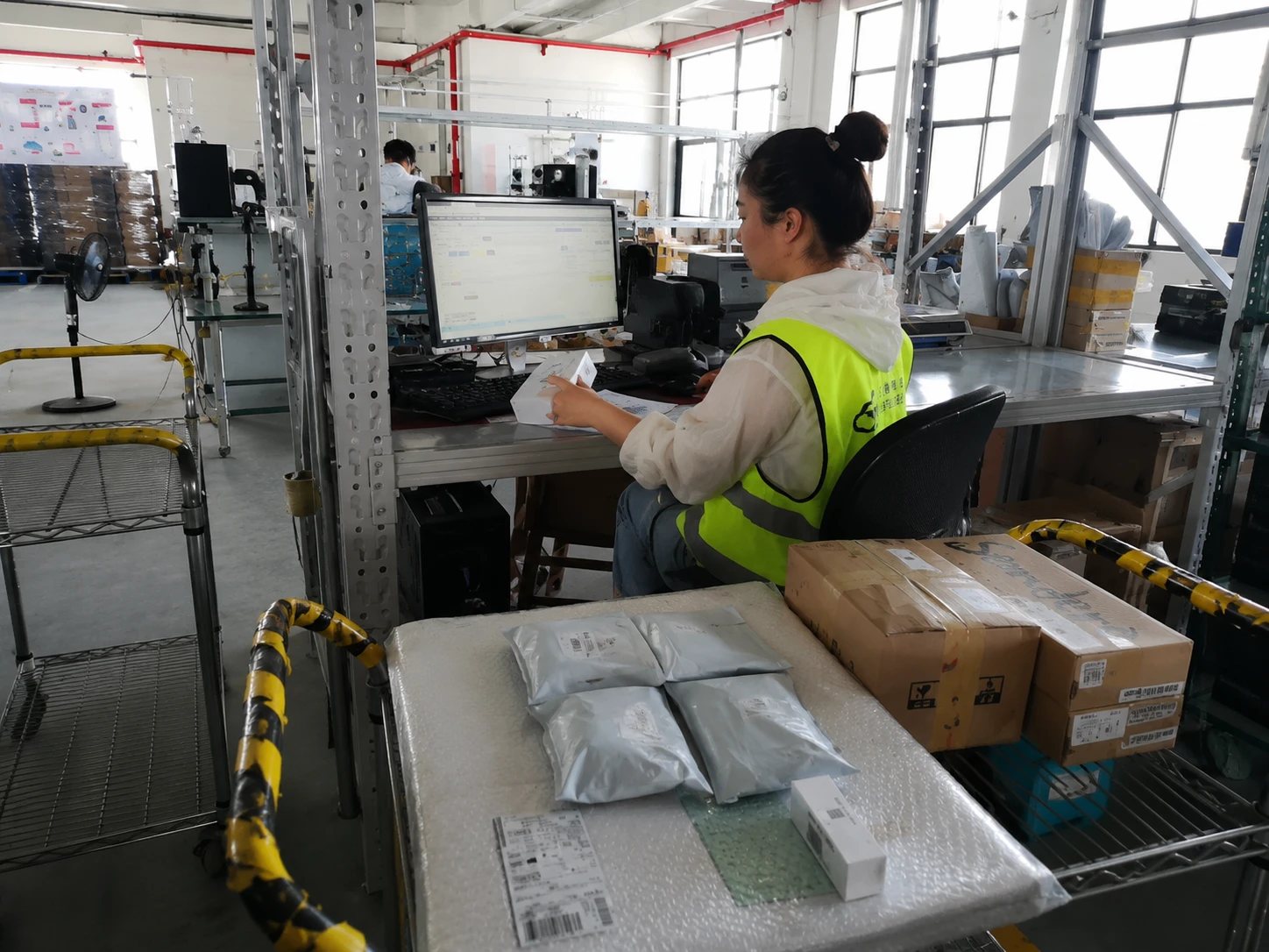 Warehouse staff member processing outbound orders at a scanning workstation